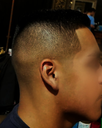 Precision skin fade with sharp razor lineup at The Mane Den Barber Shop
